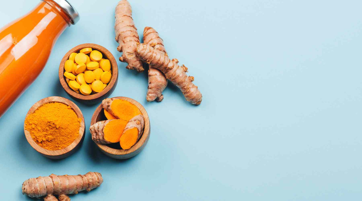 The image depicts a collection of turmeric products and raw turmeric roots. On the left, there's a bottle of turmeric liquid extract. In the center, we see small bowls containing turmeric pills, turmeric powder, and sliced turmeric root. To the right, the