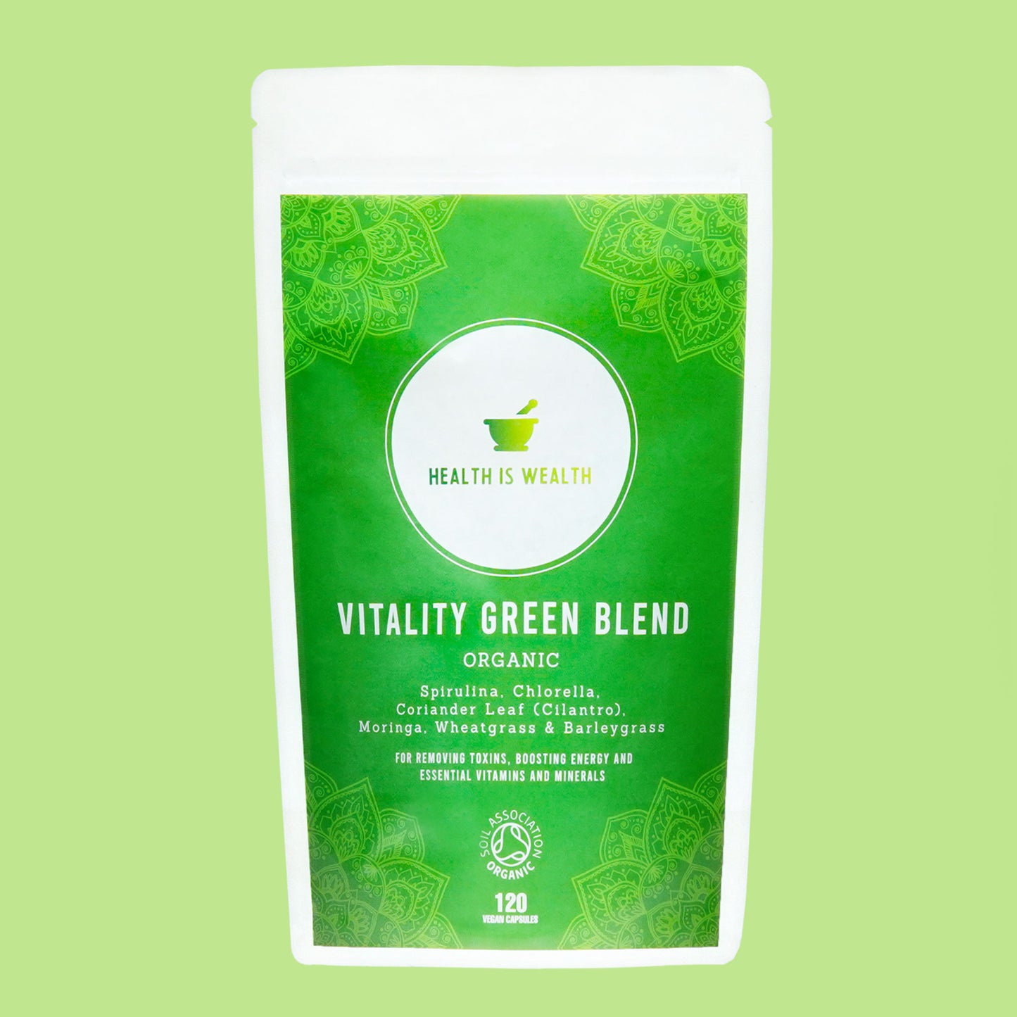 The image features a product called "Vitality Green Blend" from Health is Wealth, showcased in a vibrant green, stand-up pouch. The front of the pouch is adorned with intricate mandala designs and lists key ingredients like Spirulina, Chlorella, Moringa, Wheatgrass, Coriander Leaf (Cilantro) and Barleygrass. It's labeled as a superfood blend that supports detoxification, is a natural energy booster and provides essential vitamins and minerals. An organic food supplement containing 120 capsules.